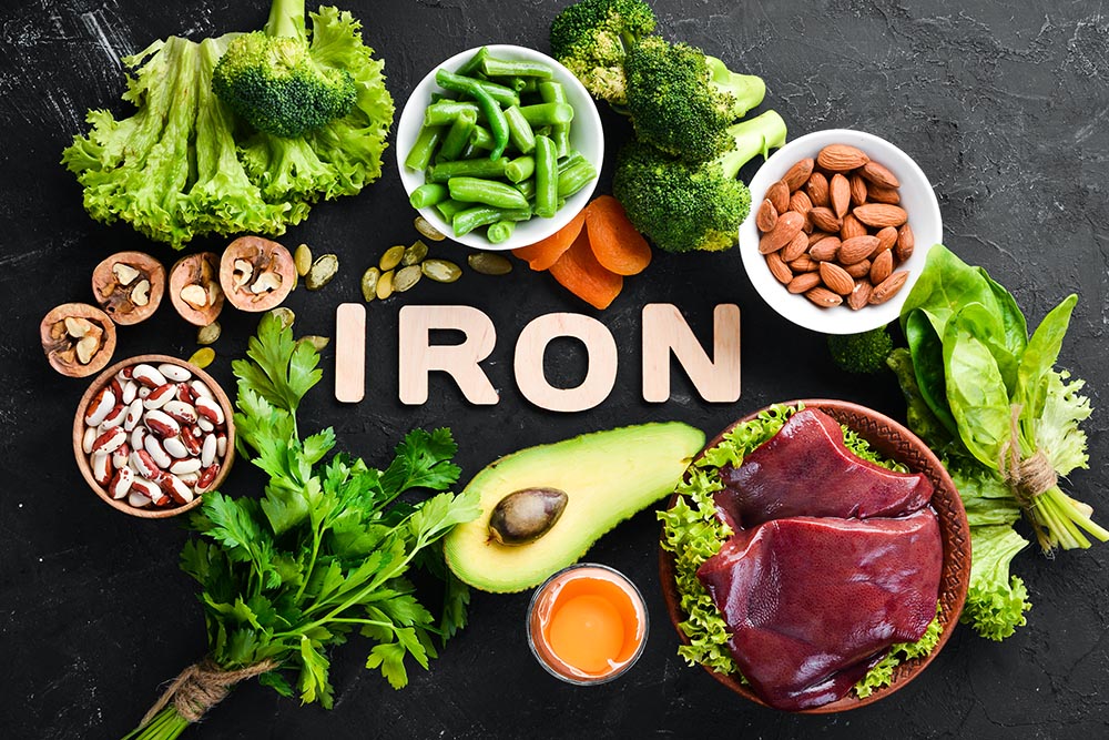 food containing natural iron fe liver avocado broccoli spinach parsley beans nuts black stone background top view